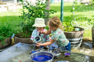 Two children playing with a tea set